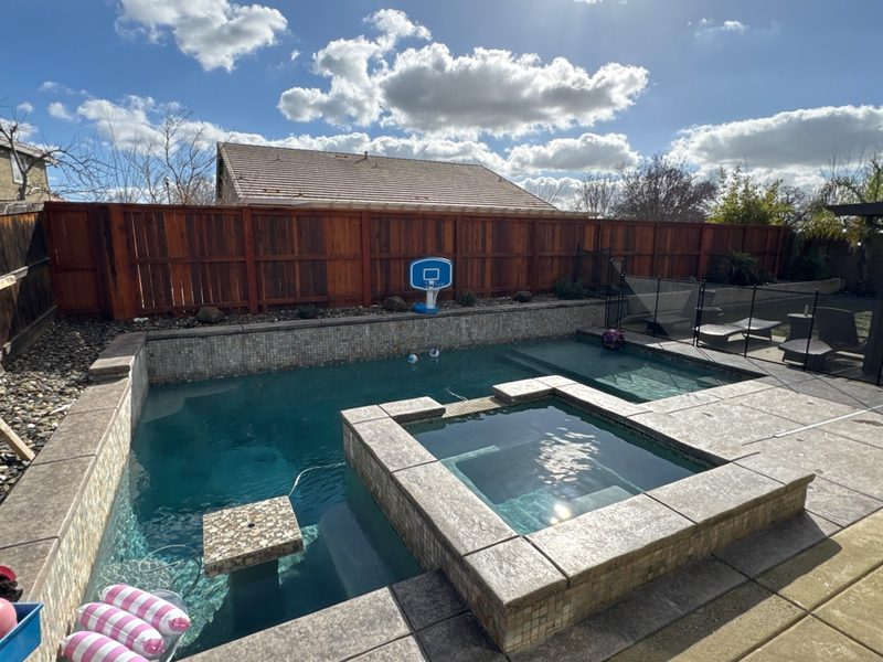 Pool and spa with mosaic tile border maintained by Private Oasis Pools in Roseville