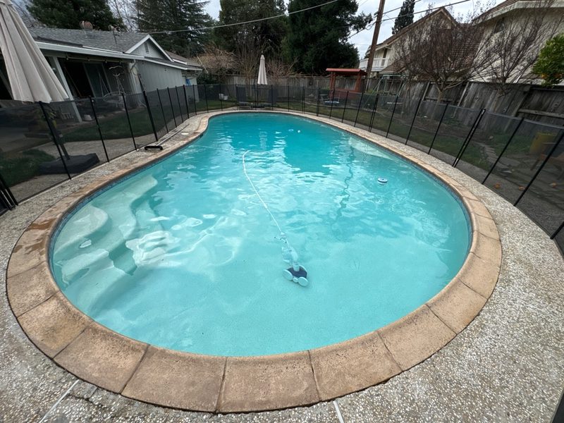 Residential pool with safety fence professionally maintained in Sacramento area